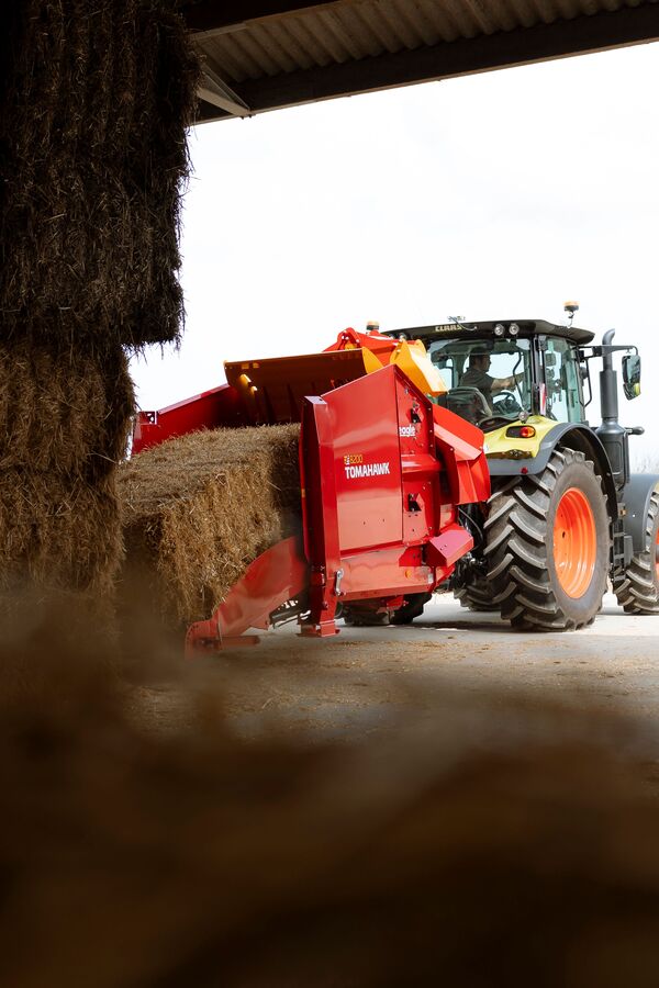 Traktor z ładowaczem słomy w stodole
