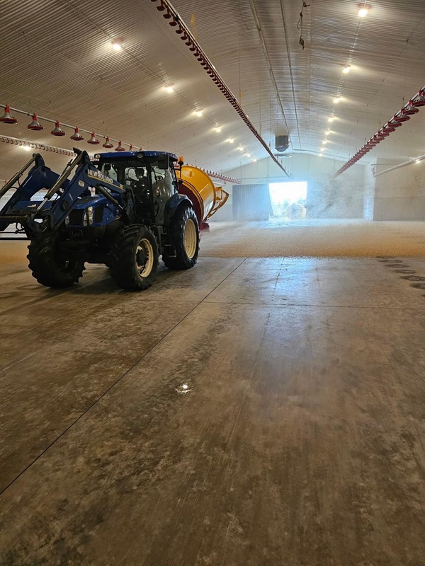 Traktor w hali magazynowej słomy